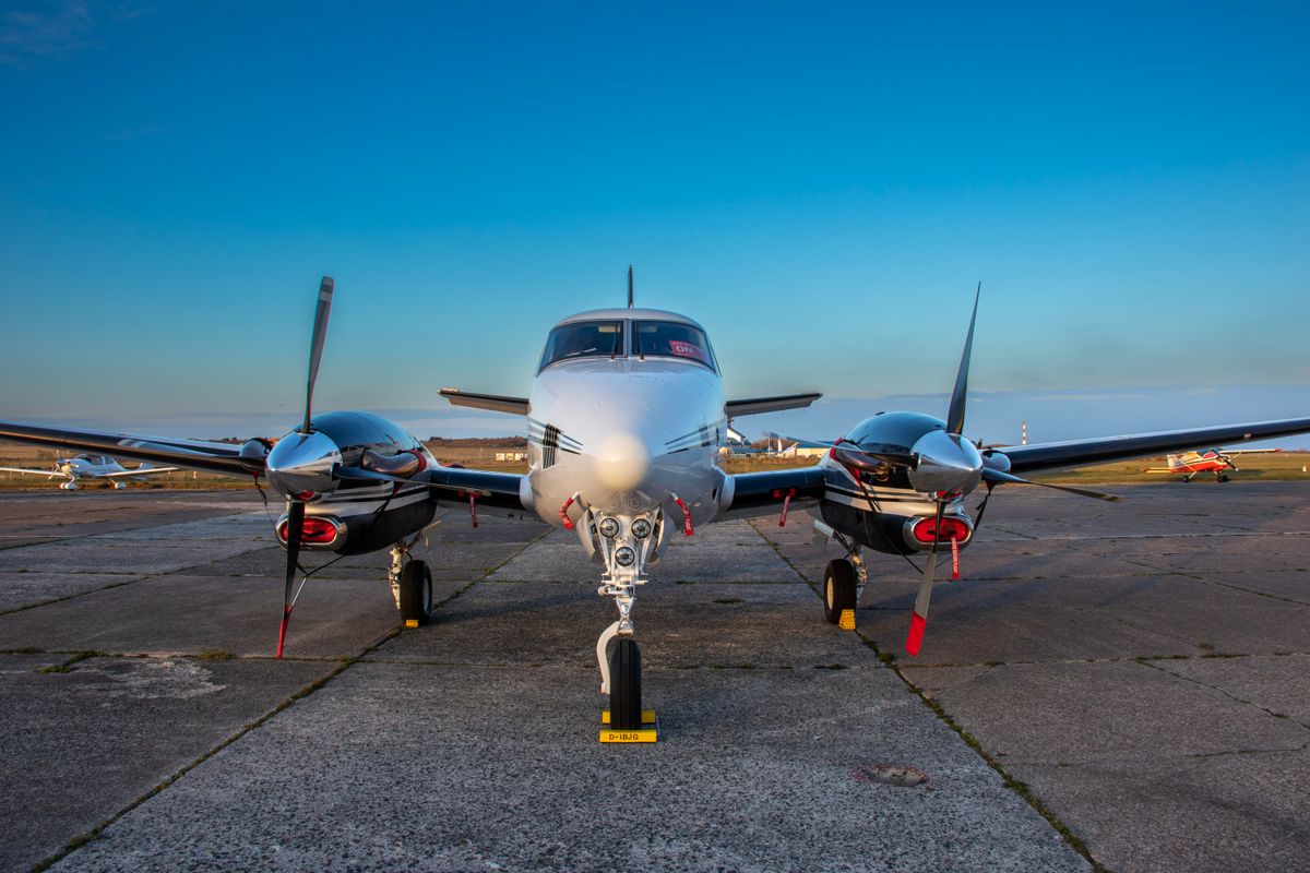 A twin-engine light aircraft on the tarmac