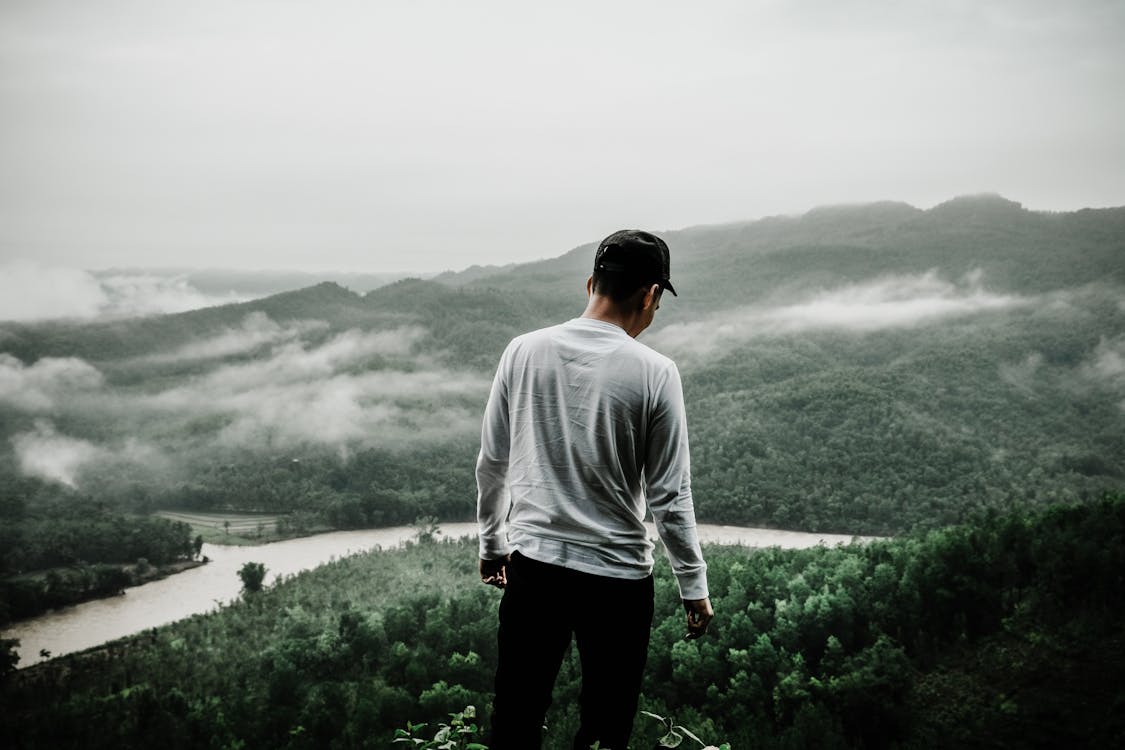 Photo of Man Standing at the Edge of a Cliff