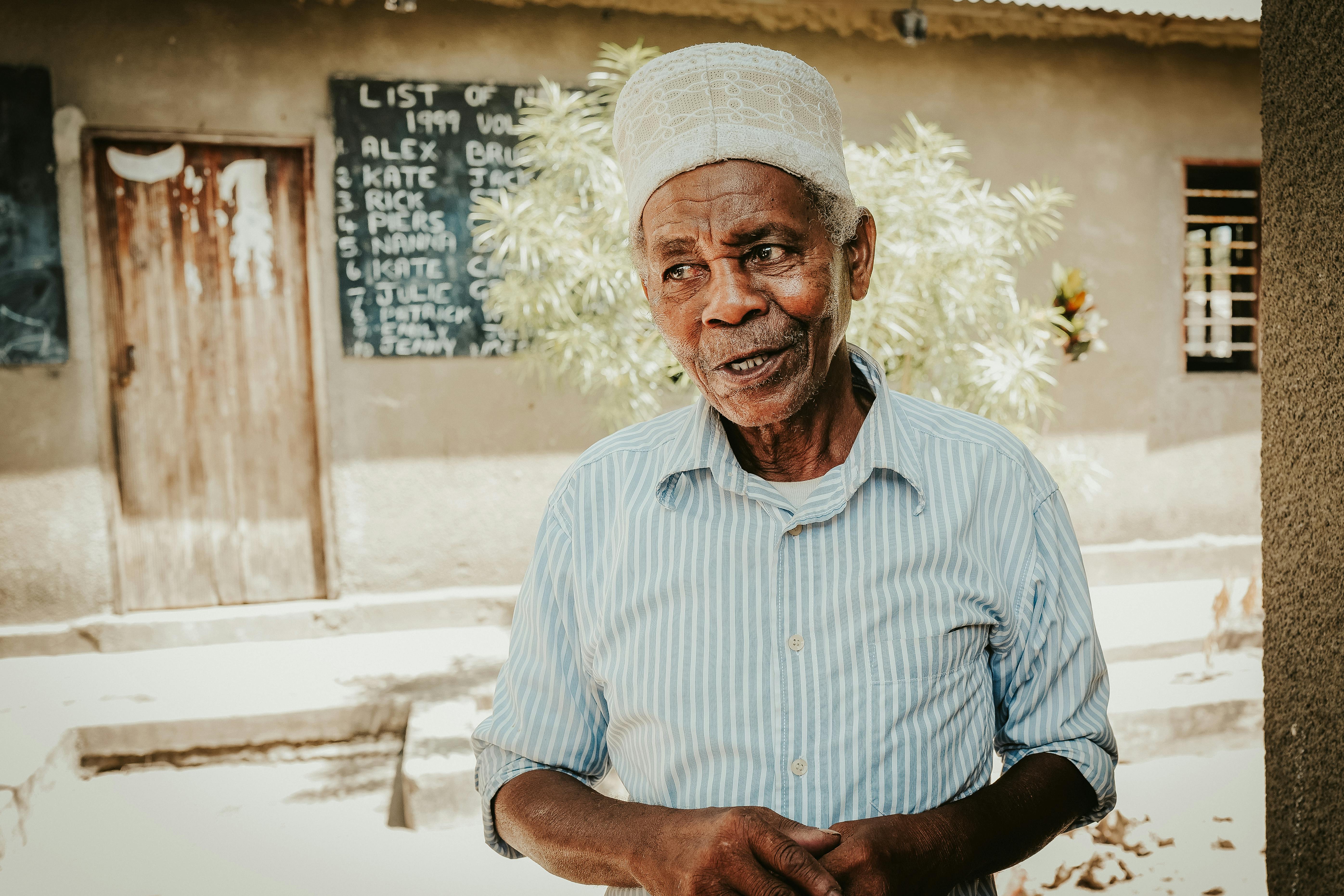 Elderly man posing outdoors in traditional clothing in Sansibar, Tanzania.
