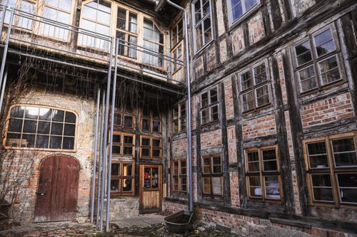Free Explore an abandoned rustic courtyard with historic timber and brick architecture in Europe. Stock Photo