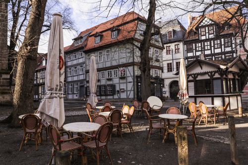 Free Quaint German town square with half-timbered buildings and empty café seating under bare trees. Stock Photo