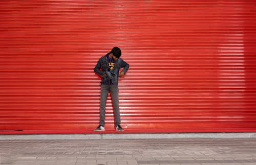 Man in Jacket Posing by Red Wall