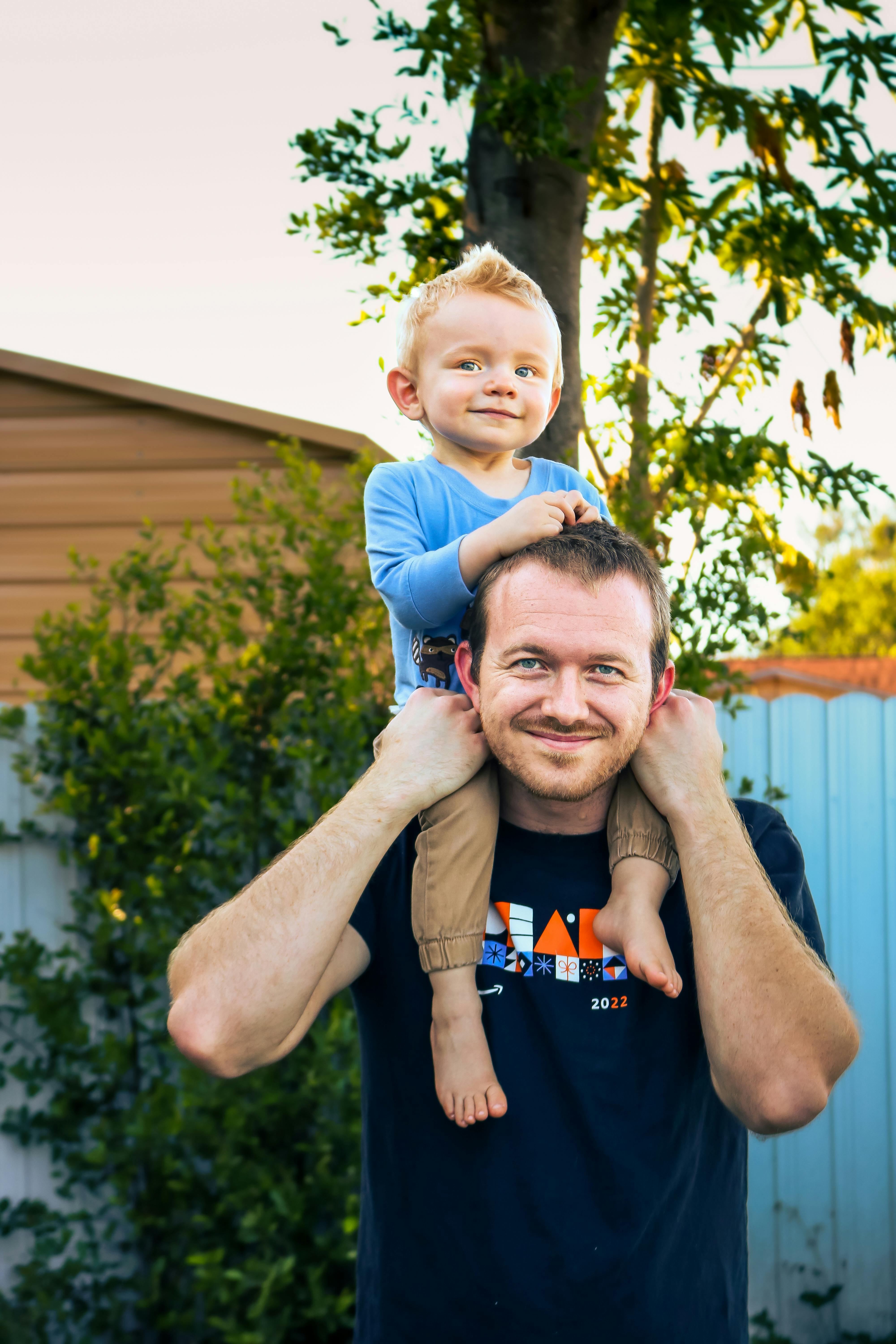 smiling father carrying son