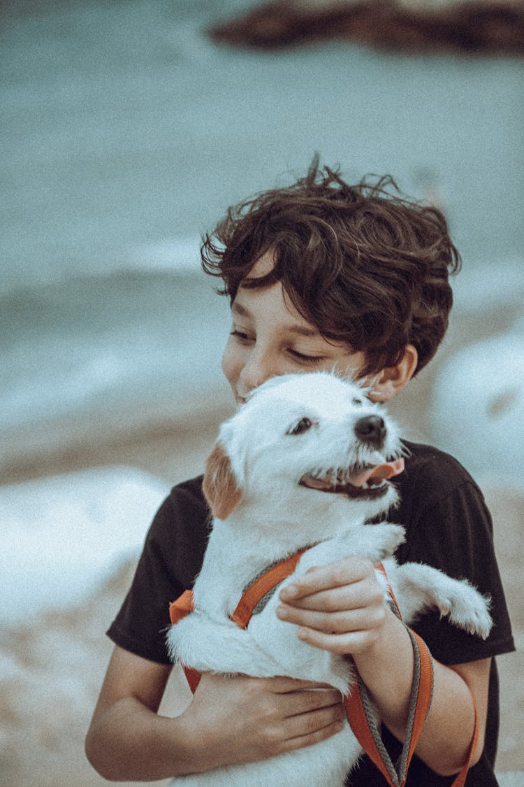 Young Boy Holding Happy Dog In His Arms