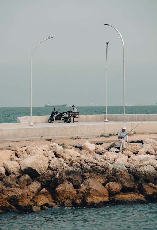 Men Fishing and Sitting with Motorcycle on Pier