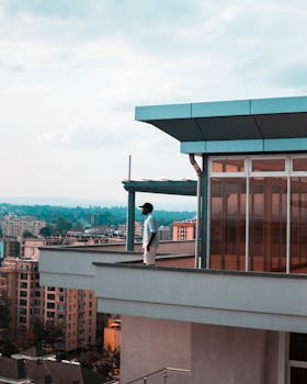 一名男子站在现代风格的阳台上，俯瞰着城市的天际线