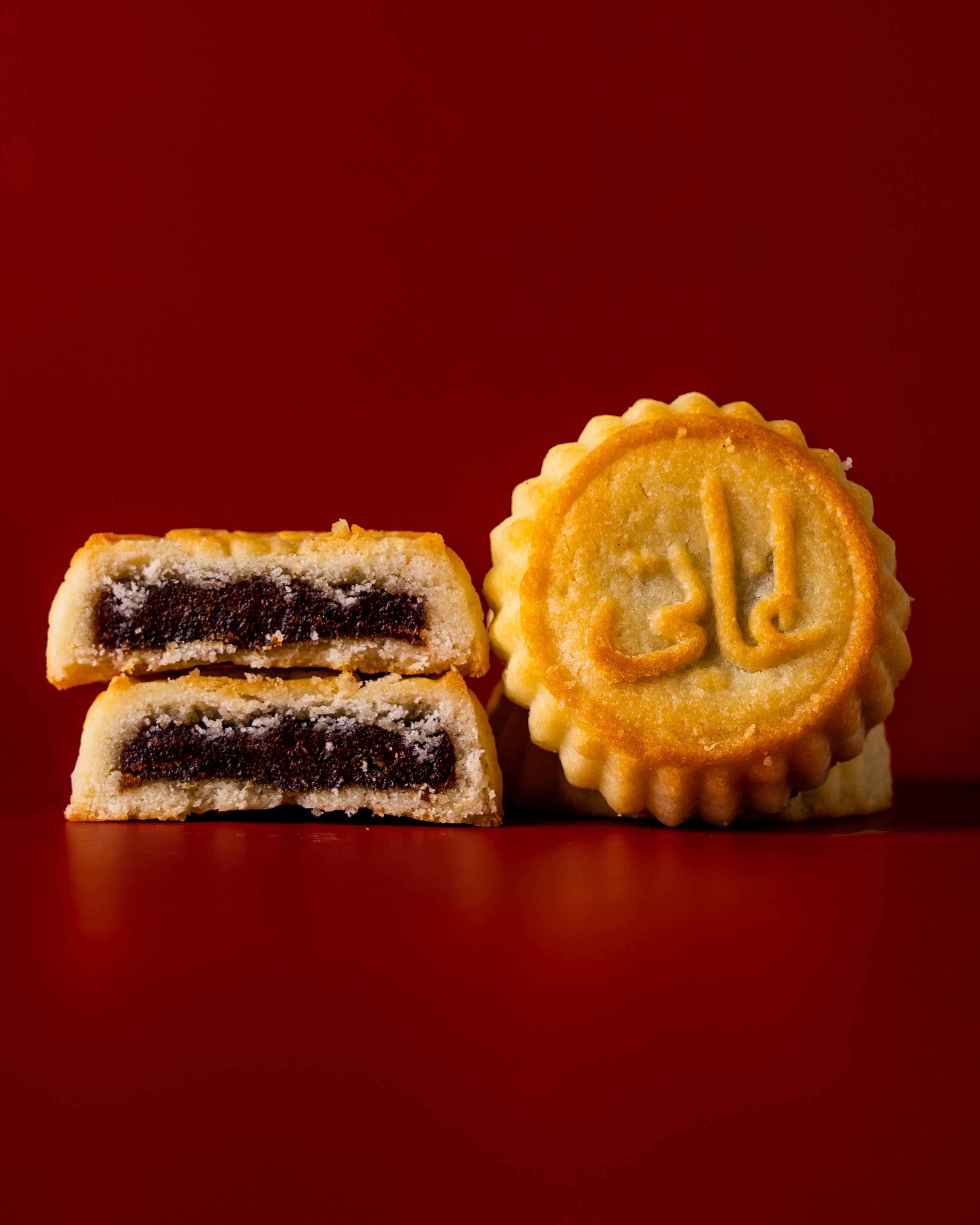 Close-up of delicious cookies with filling on a vibrant red backdrop. Perfect for dessert lovers.