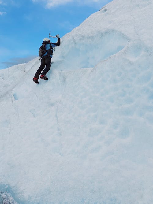 Alpinist Climbing in Snow