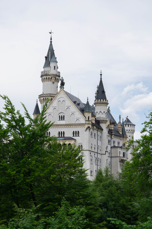 Free Stunning view of Neuschwanstein Castle prominently framed by lush greenery in Bavaria, Germany. Stock Photo