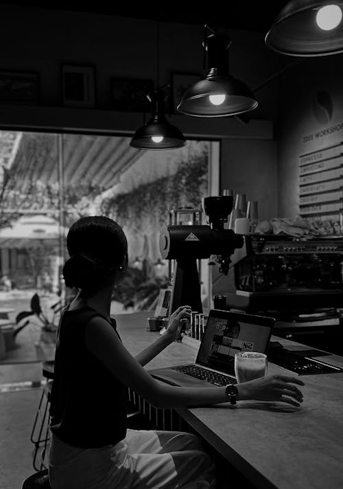 Free Woman with Coffee Working on Laptop in Cafe Stock Photo