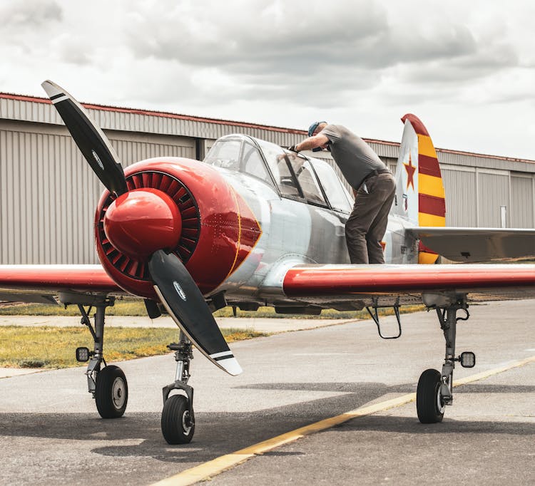 A Man Standing On The Side Of A Trainer Aircraft 