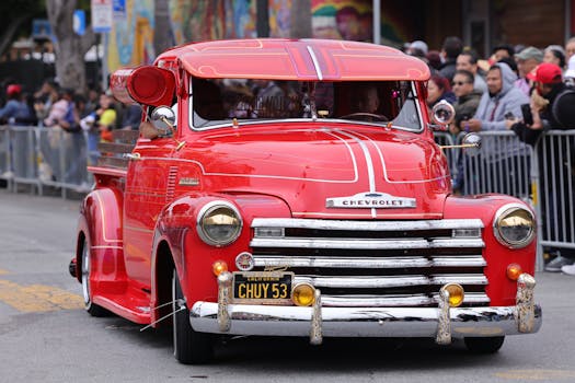 A nostalgic red Chevrolet vintage truck displayed at a classic car show parade event.