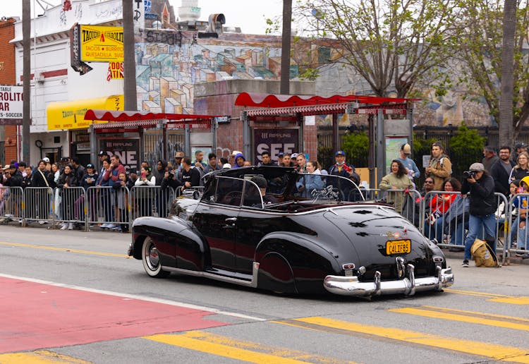 People Watching Vintage, Black Cabriolet On Street