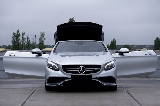 Front view of a Mercedes-Benz luxury convertible with open doors in a parking lot.