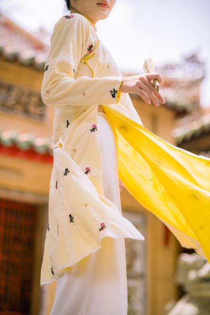 Close-up of a woman in a flowing yellow traditional dress in an outdoor setting, showcasing a cultural ambiance.