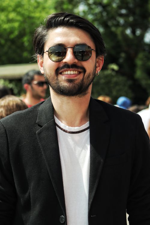 Free Portrait of a smiling man in sunglasses and a black suit outdoors. Stock Photo