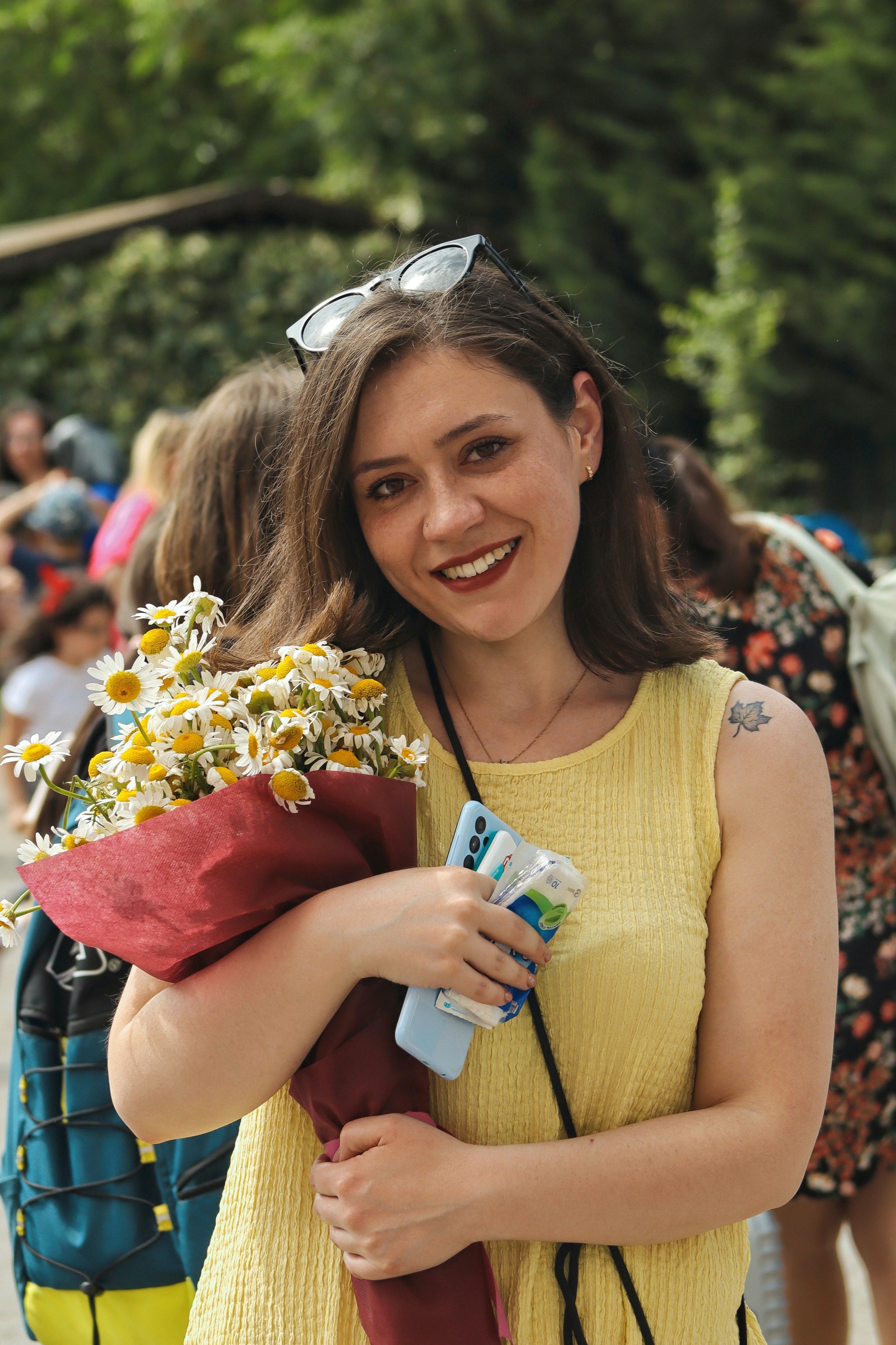 Young Woman in a Dress Holding a Bunch of Flowers and Smiling · Free ...