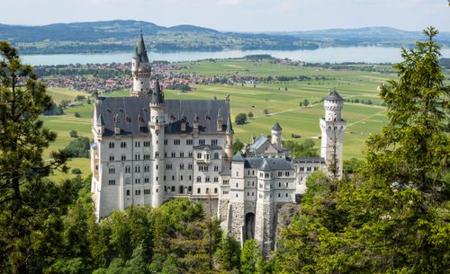 Free A stunning view of Neuschwanstein Castle surrounded by lush greenery in Bavaria, Germany. Stock Photo