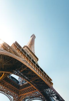 Stunning low angle shot of the Eiffel Tower in Paris with a clear blue sky, perfect for travel enthusiasts.