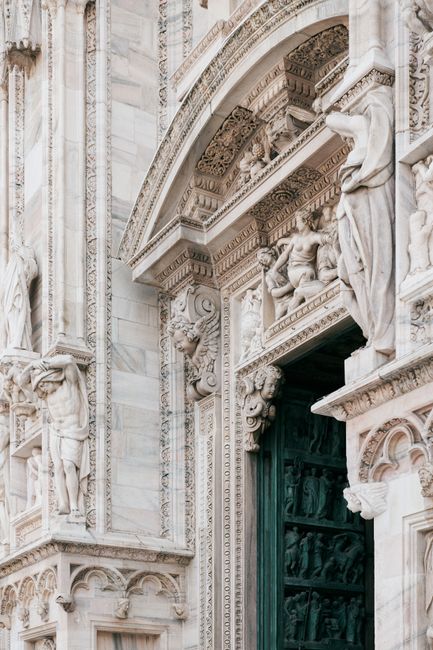 Intricate gothic architectural details at the entrance of Milan Cathedral, Italy.