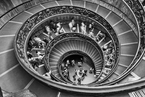 People Walking Downstairs on Circular Staircase