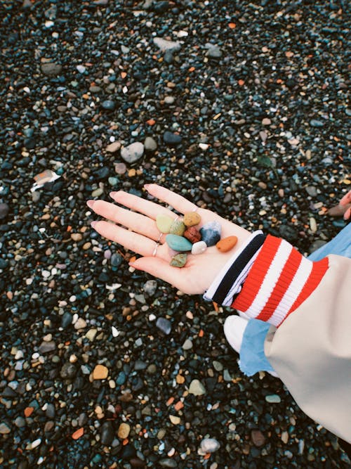 Close-up of Woman Holding Pebbles on Her Hand 