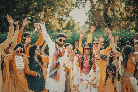 A joyous outdoor South Asian wedding celebration with dancing and traditional attire.