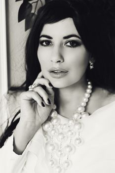 A sophisticated black and white portrait featuring a woman adorned with elegant jewelry.