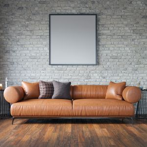 Leather sofa against a brick wall in a loft living room. Photo by Marko Stojkovic on Pexels