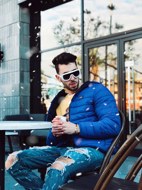 Man Holding Cup While Sitting