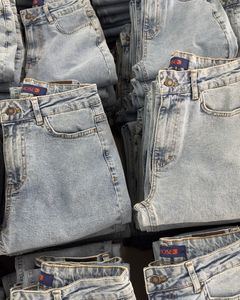 Close-up of folded blue jeans stacked neatly on a retail display.