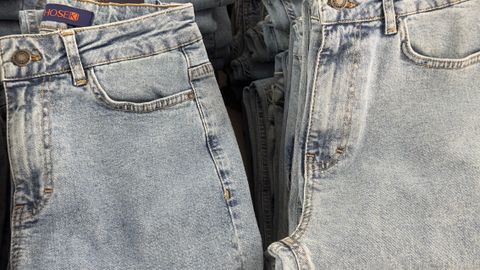 Close-up of folded blue jeans stacked neatly on a retail display.