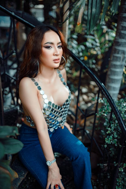 Model Posing in Glistening Silver Top and Jeans