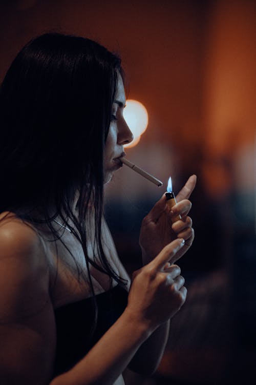 Woman Lighting Cigarette at Night