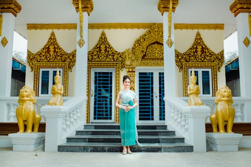 Woman in Traditional Dress against Buddhist Temple