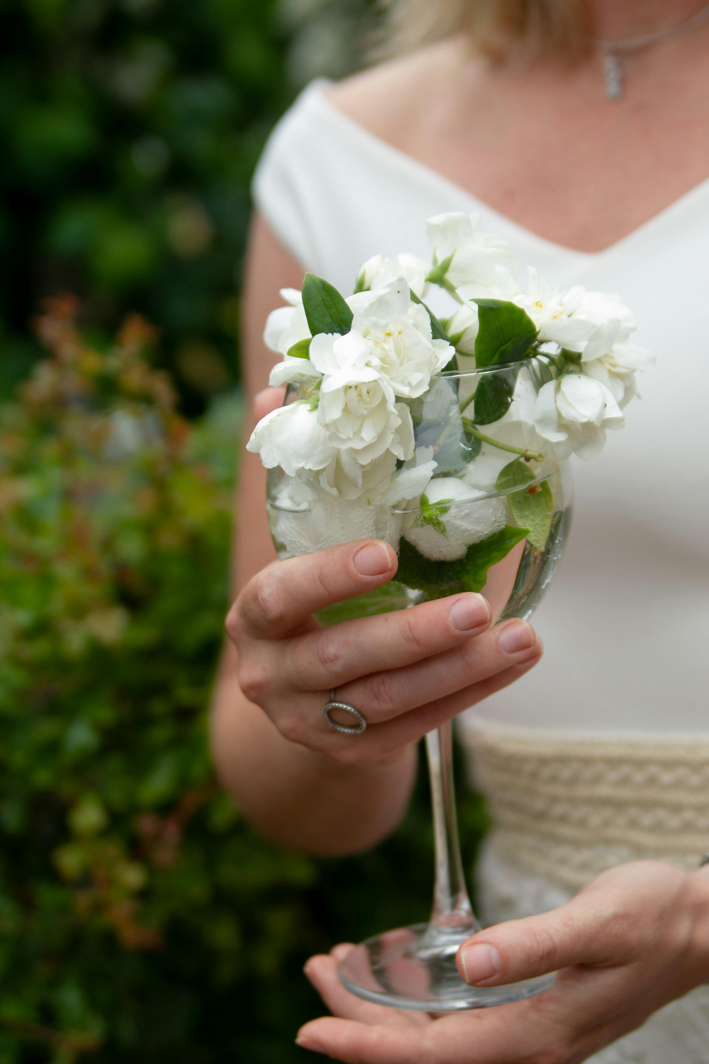 woman hands holding glass with flowers