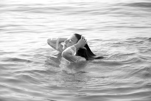 Free Black and white image of a woman enjoying the calm waters with eyes closed, evoking tranquility. Stock Photo