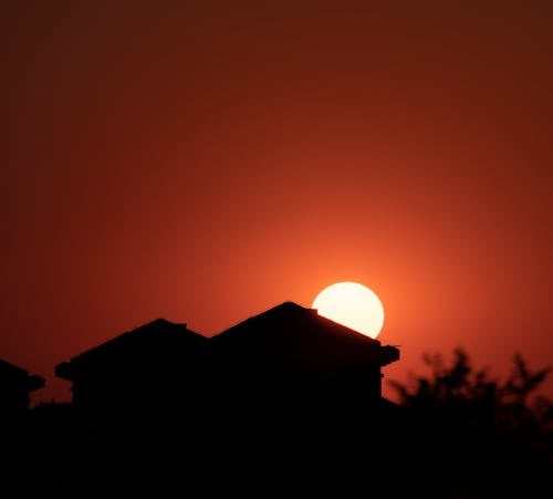 Sun on Red Sky over Buildings Silhouette at Sunset