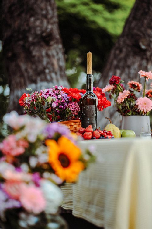 Free Colorful floral arrangement and wine bottle on table outdoors, exuding fresh, bright, and festive vibes. Stock Photo