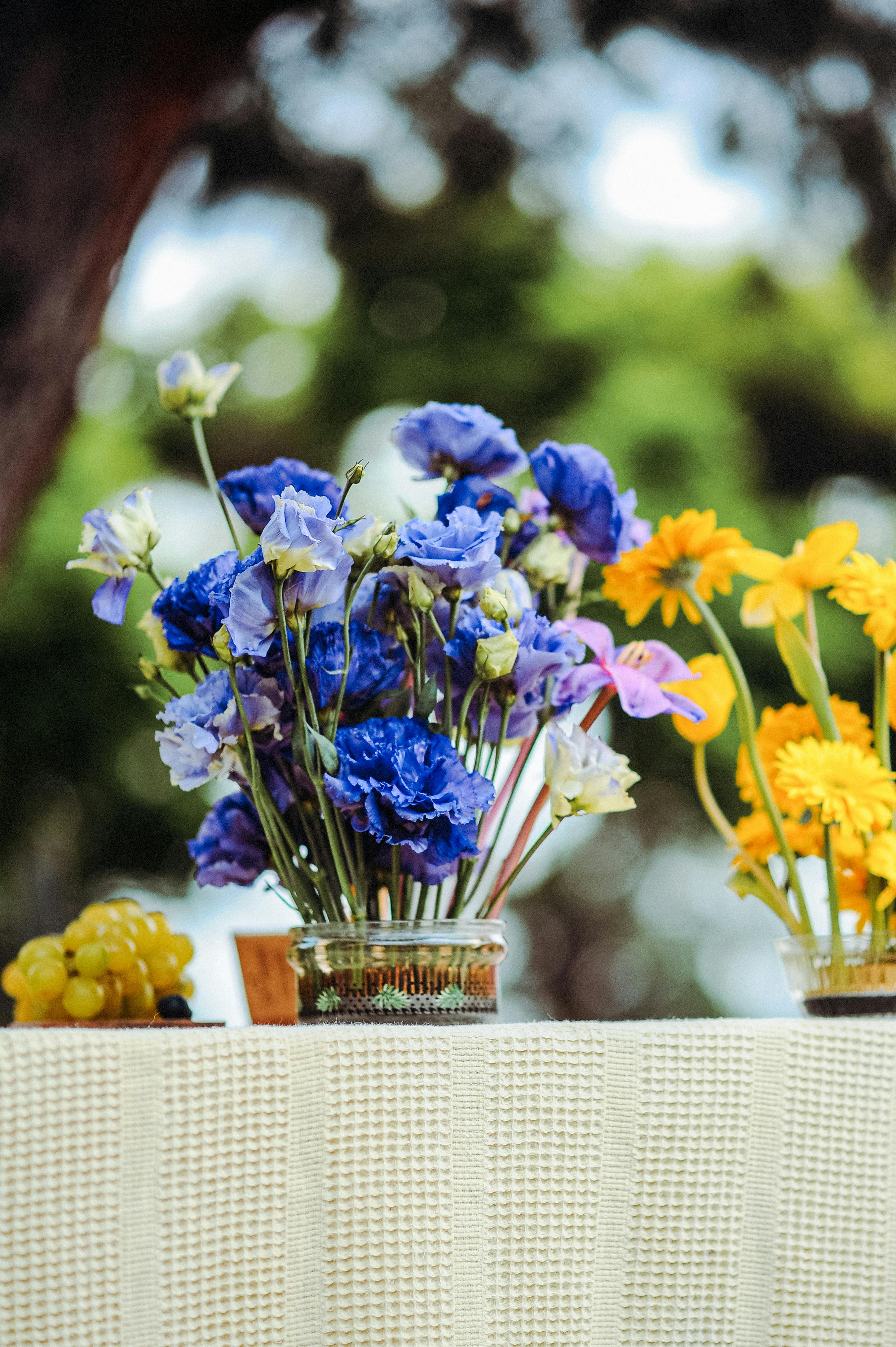 Blue and Yellow Flower Arrangements Decorating a Table in a Garden