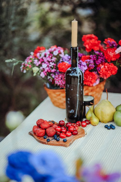 Free Vibrant still life featuring fruits, flowers, and candlestick on a table. Stock Photo