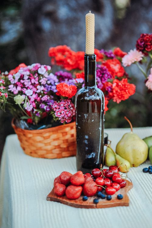 Free Bright flowers, fresh fruits, and a candle create a vibrant still life scene on a table. Stock Photo