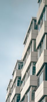 Vertical shot of a modern geometric facade building under a clear sky, emphasizing urban architecture.