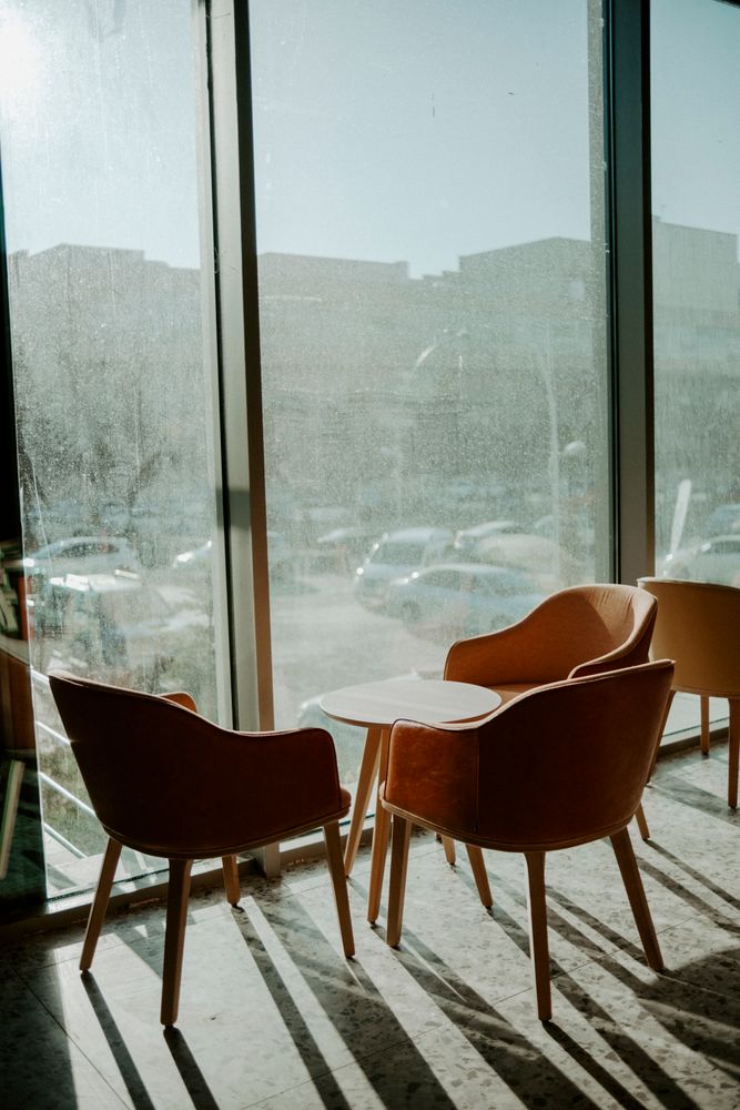A calm seating area with armchairs beside a large sunlit window, a peaceful reflective space