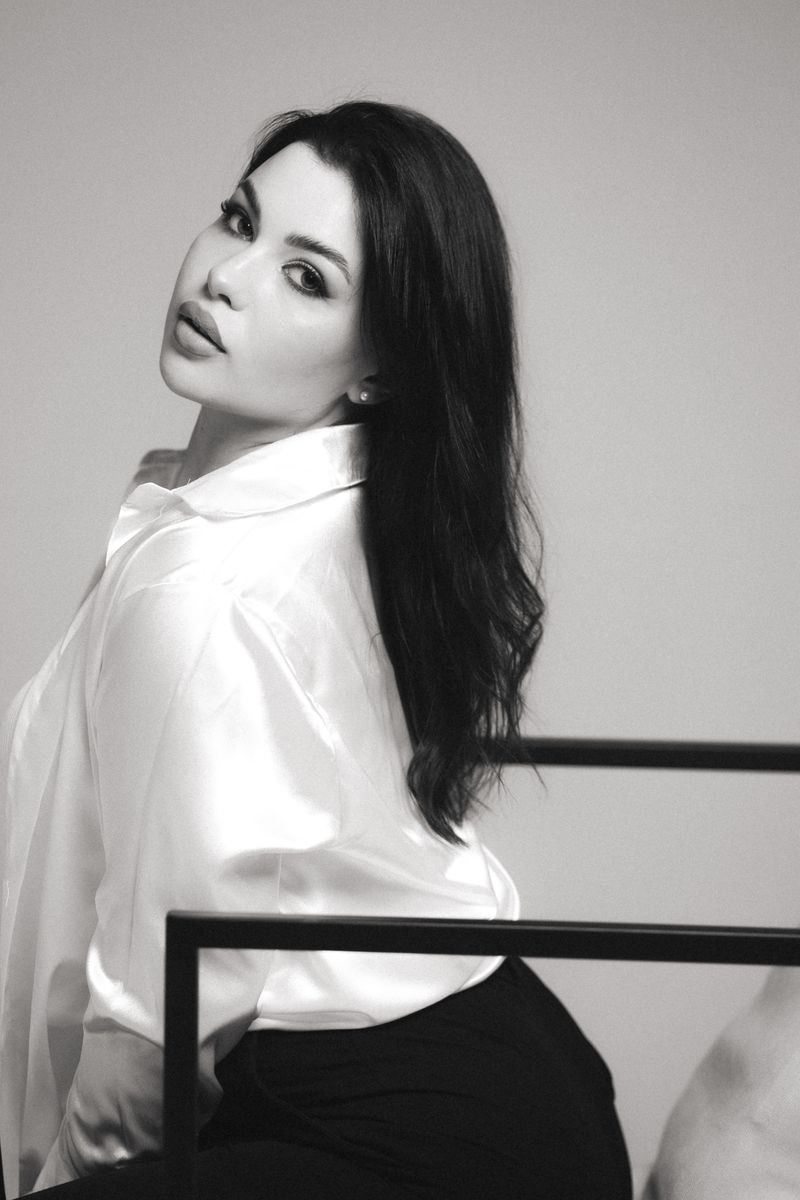 woman in black satin trousers and ivory silk shirt
