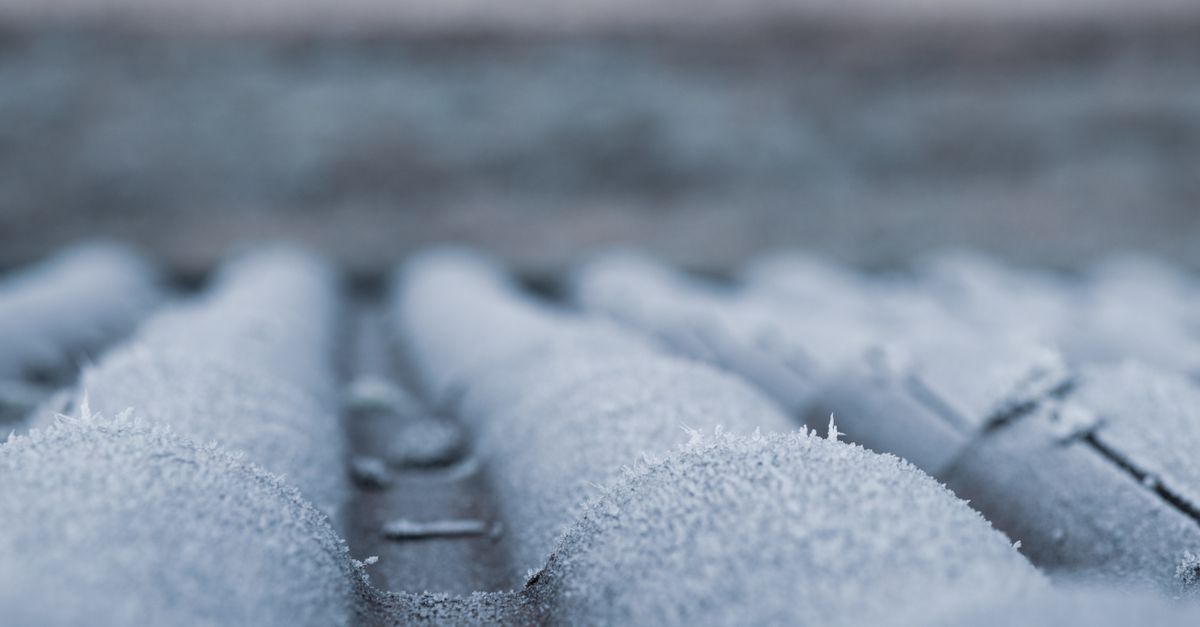 Close-up of frosty roof shingles showcasing winter's icy grip and cold atmosphere.