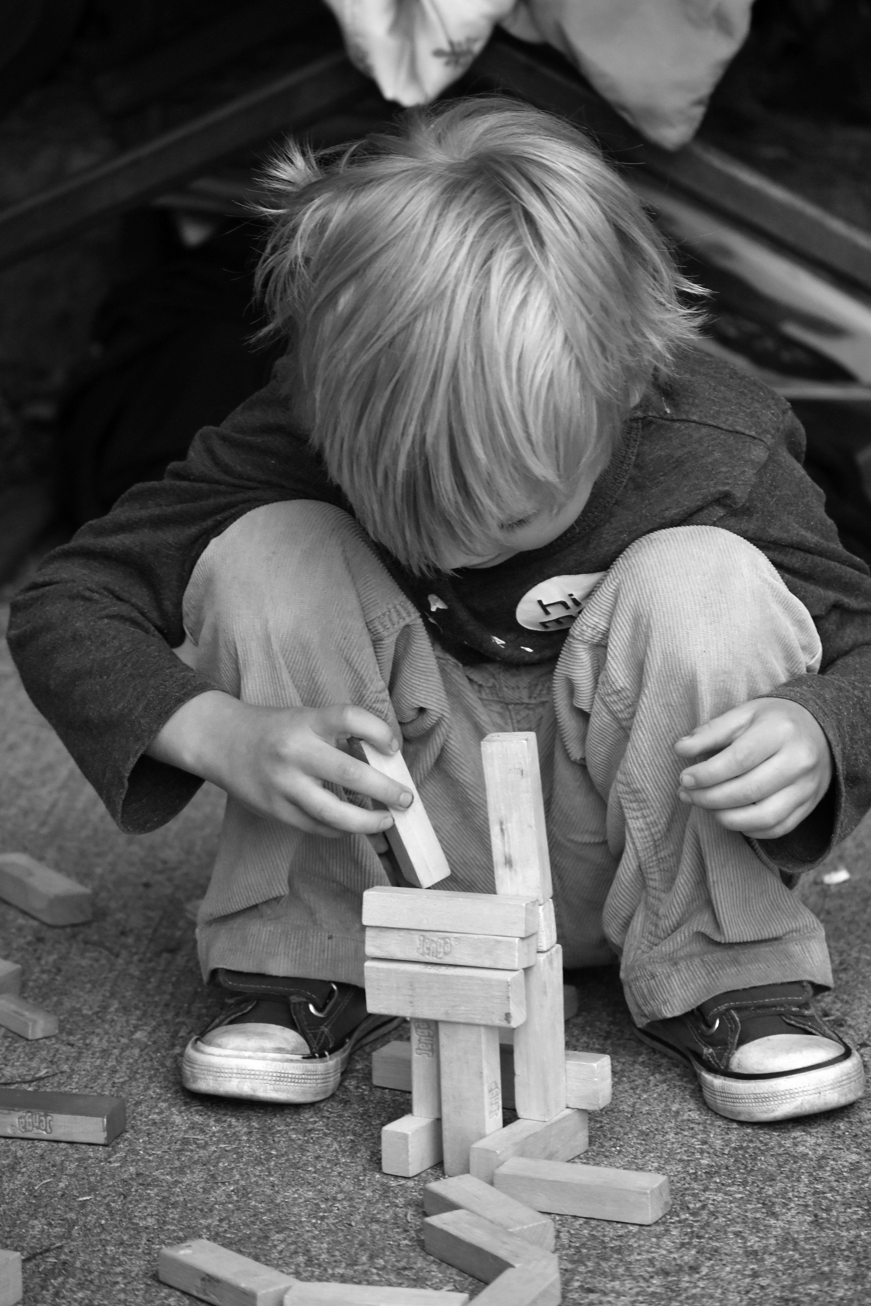 Black and White Photo of a Boy Playing with Toy Blocks · Free
