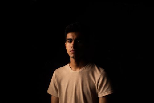 Free Dark, moody portrait of a man with soft lighting and black background. Stock Photo