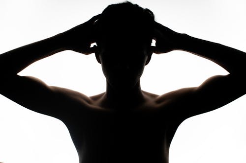Silhouette of a Young Shirtless Man Posing in Studio 