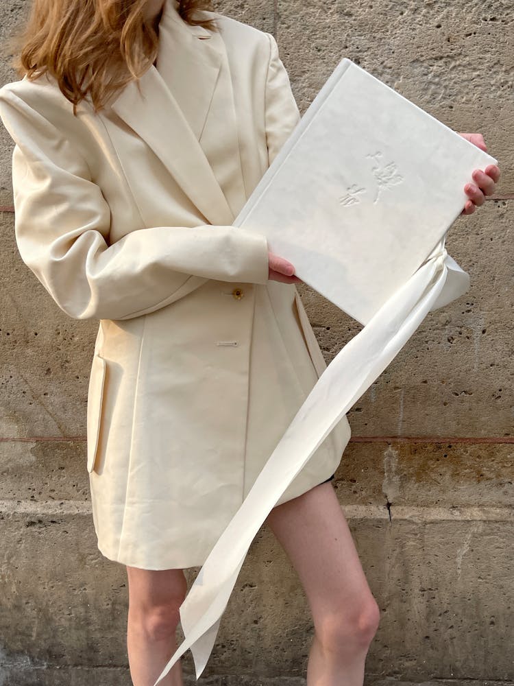 Woman In White Coat Holding Decorated Book